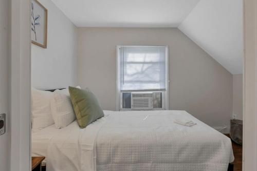 a white bed in a room with a window at Housepitality - West Side Lodge - 6 BR 2 BA in Columbus