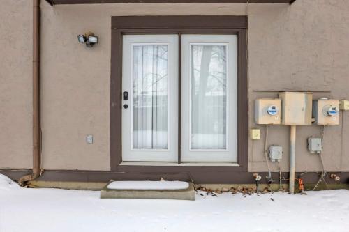 a door to a building with snow on the ground at Housepitality - The Gahanna Hideaway in Gahanna