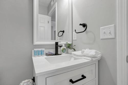 a white bathroom with a sink and a mirror at The Schumacher Townhouse - 2 BR in Columbus