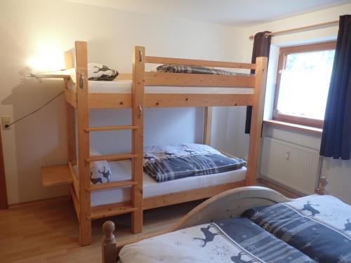 a bedroom with two bunk beds and a bed at Chiemgauferienwohnungen - Wanderlust und Alpenrose in Unterwössen