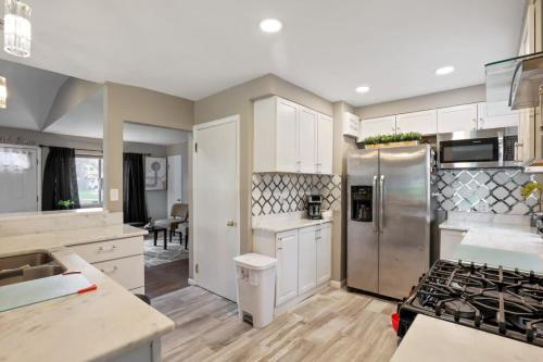 a kitchen with white cabinets and a stainless steel refrigerator at The Blue Door Dream - Stunning design Very Quiet in Columbus