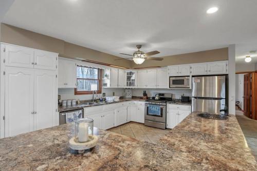 a large kitchen with white cabinets and a counter top at Housepitality - The Indian Lake Escape - 4 BR in Huntsville