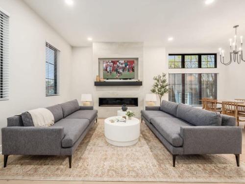 a living room with two couches and a table at Chateau in the Village - Brand New 3BD 5BA in Columbus