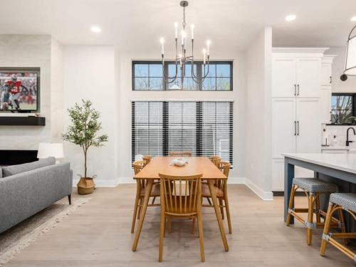 a kitchen and dining room with a wooden table and chairs at Chateau in the Village - Brand New 3BD 5BA in Columbus