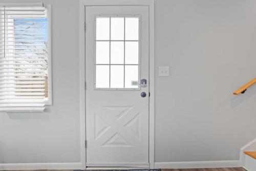a white door in a room with a window at Housepitality - The Restful Studio - Cozy in Newark