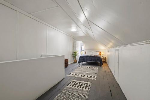 ein Schlafzimmer mit einem Bett in einem weißen Zimmer in der Unterkunft Housepitality - Cityscape - Historic 2BR in Columbus