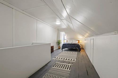 a bedroom with a bed in a white room at Housepitality - Cityscape - Historic 2BR in Columbus