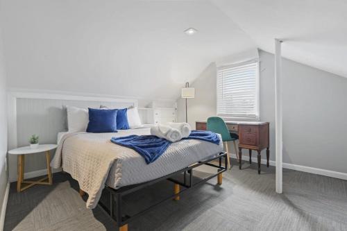 1 dormitorio con cama con almohadas azules y escritorio en Housepitality - Newark Friends and Family House, en Newark