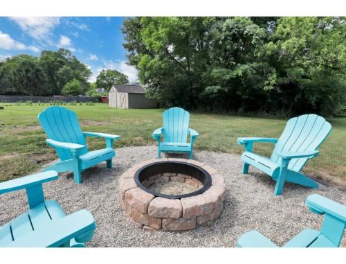 three blue chairs sitting around a fire pit at Housepitality - Little River Trails in Mason