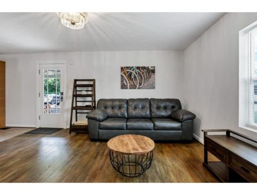 a living room with a leather couch and a table at Housepitality - Little River Trails in Mason