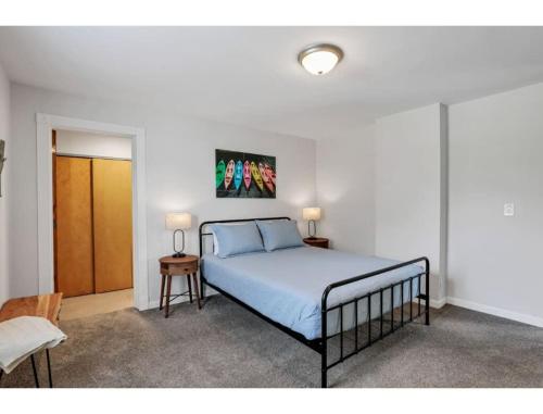 a bedroom with a bed and two tables and a door at Housepitality - Little River Trails in Mason