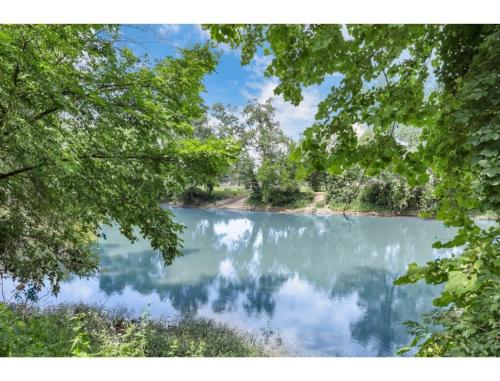 a view of a lake through the trees at Housepitality - Little River Trails in Mason