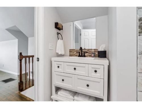 a bathroom with a white sink and a mirror at Housepitality - Little River Trails in Mason