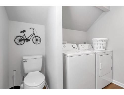 a bathroom with a toilet and a bike on the wall at Housepitality - Little River Trails in Mason