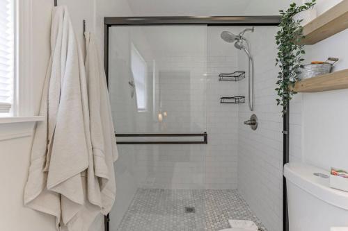 ein weißes Bad mit einer Dusche und einem Handtuch in der Unterkunft The Eastlawn Ranch 3BD 2BA in Columbus