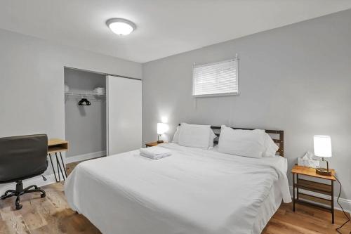 Habitación blanca con cama grande y escritorio. en German Village Hidden Gem - 3 BR, Parking l Value en Columbus
