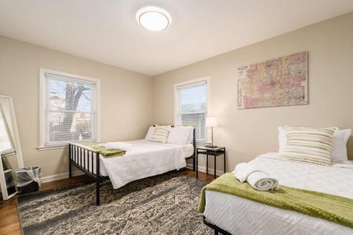 1 Schlafzimmer mit 2 Betten und 2 Fenstern in der Unterkunft Housepitality - The OSU Mansion- OSU Sleeps 20 in Columbus