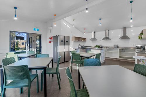 a kitchen and dining room with tables and chairs at Tasman Holiday Parks - Rotorua in Rotorua