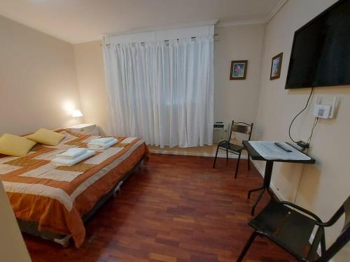 a bedroom with a bed and a desk and a television at Hermoso Departamento monoambiente, excelente ubicación a 50 mts de Plaza principal in Salta