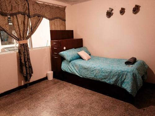 a small bedroom with a bed and a window at Casa completa en Xela in Quetzaltenango