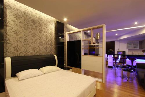 a bedroom with a bed and a kitchen with a bar at Kuala Lumpur Regalia Deluxe Suite in Kuala Lumpur