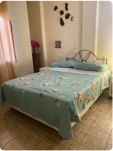 - un lit avec un couvre-lit bleu et des fleurs dans l'établissement Apartamento de ensueño, à Santa Cruz de la Sierra