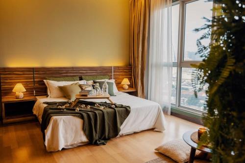 a bedroom with a large bed and a christmas tree at KLCC View Savannah- In a Tropical State of Mind in Kuala Lumpur