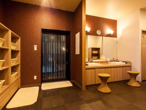 een grote badkamer met een wastafel en een spiegel bij Hotel Route Inn Miyoshi Ekimae in Miyoshi