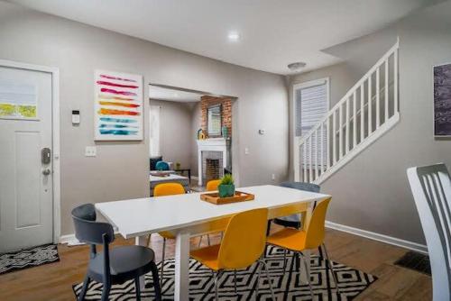 a dining room with a white table and yellow chairs at Housepitality - The Lilley Pad - Near Downtown in Columbus