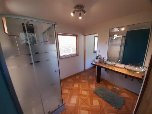 y baño con ducha, 2 lavabos y espejo. en Casona en Valle Los Coligues, en Quilpué