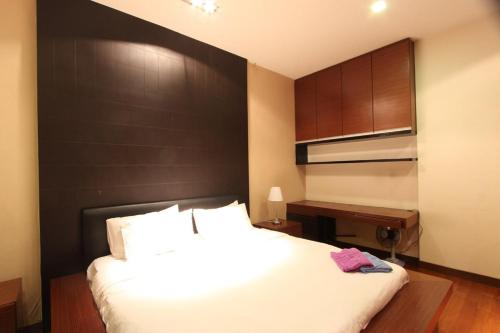 a bedroom with a large bed and a desk at Lavish Loft 12 Steps Away From Bukit Bintang in Kuala Lumpur