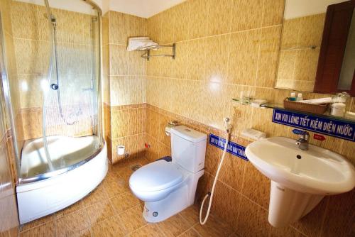 een badkamer met een toilet, een wastafel en een douche bij Hotel Hải Châu in Ấp Phước Thọ