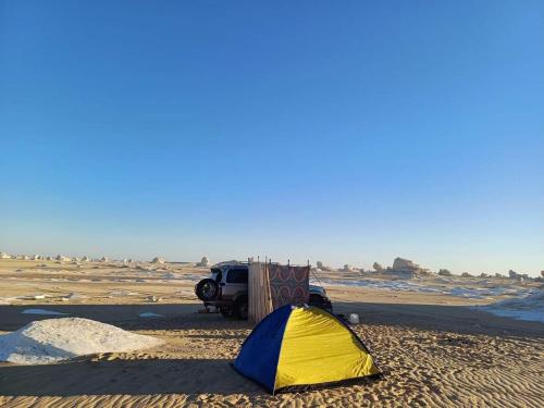 a tent and a truck in the desert at Abo Yusre Sfari in Bawiti