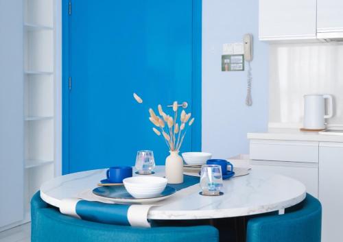 - une cuisine bleue et blanche avec une table et des chaises dans l'établissement 1BR Peace of Mind Mediterranean Style Condo, à Kuala Lumpur