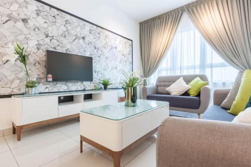 a living room with a tv on a wall at NaiBnB in Impiria Residensi in Klang