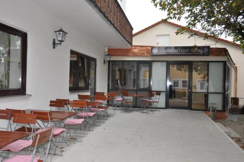 a group of tables and chairs in front of a building at Landgasthof Hepting in Massenhausen