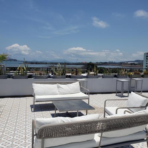 a patio with couches and tables on a roof at Departamento en Casco Antiguo in Panama City