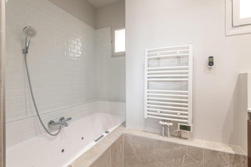 a white bathroom with a tub and a shower at PANORAMIC SUITE - SUPERB flat in the heart of the old town 5 stars in Annecy