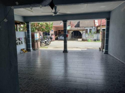an empty garage with a brick floor and a building at ZR Homestay Kemaman with 3 Bedroom 2 Bathroom - 2 Room AC 1 Room Fan - Not Sharing House in Cukai