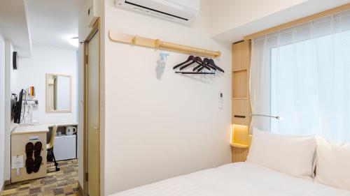 una camera con un letto bianco e una finestra di Toyoko Inn Osaka Namba ad Osaka