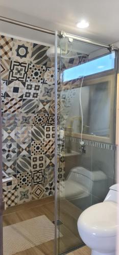 a bathroom with a glass shower with a toilet at Refugio entre el cielo AQUA in Guatavita