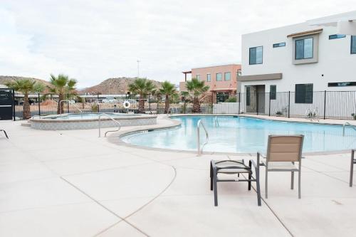 a swimming pool with two chairs next to a building at Townhome w Private Hot Tub Air Hockey and more in Washington