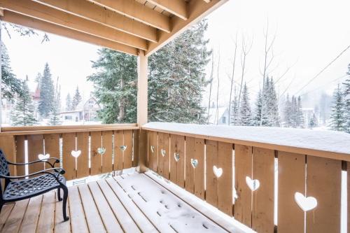 a snowy porch with a bench and hearts on the fence at Brighton Ski Resort Hidden Falls 1 Bedroom Chalet Utah in Brighton