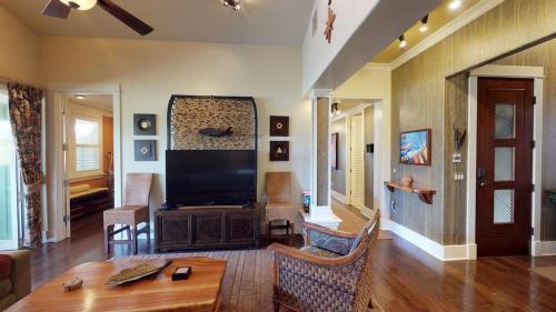 a living room with a large television and a table at C300 Custom 4 bedroom Ocean View Penthouse in Koloa