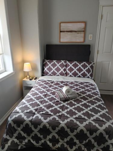 a bedroom with a bed with a black and white comforter at 32 jean economic room 1.6 in Saint John