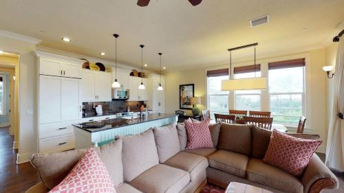 a living room with a couch and a kitchen at D210 Second Floor 3-bedroom Poolside Lanai in Koloa