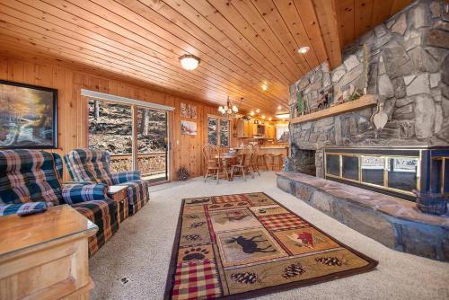 a living room with a stone fireplace in a cabin at Holliday House in Rapid City