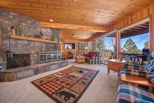 a living room with a stone fireplace in a cabin at Holliday House in Rapid City