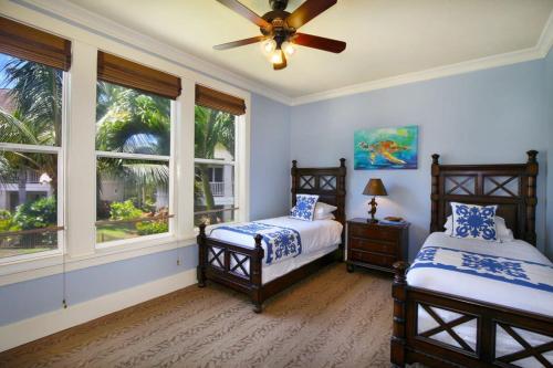 two beds in a bedroom with two windows at D211 Second Floor 3-bedroom Poolside Lanai in Koloa