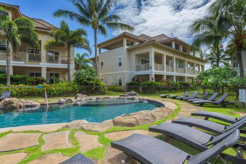 a resort with a swimming pool and lounge chairs at F211 Second Floor 3-bedroom Poolside Lanai in Koloa